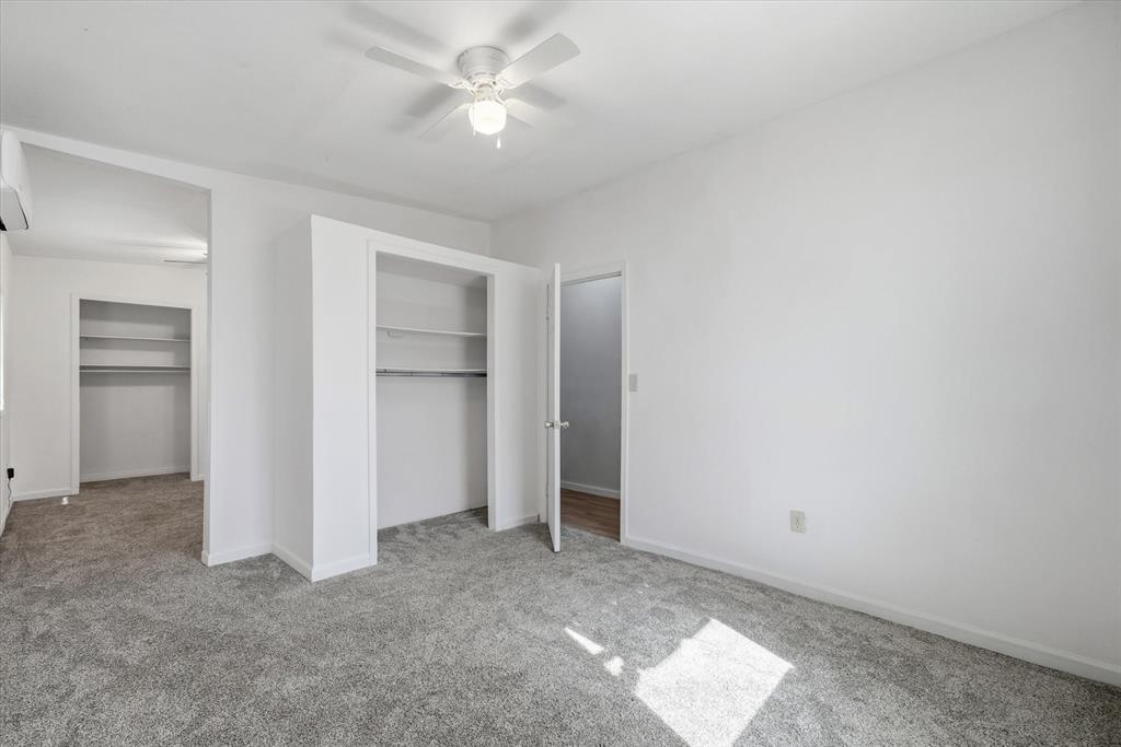 1729 Elliot Drive Canton, TX 75103 - Photo 29 of 40 Split Connecting bedroom featuring light colored carpet, a ceiling fan, and multiple closets