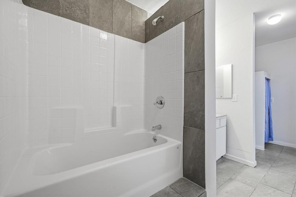 1729 Elliot Drive Canton, TX 75103 - Photo 33 of 40 Bathroom with vanity, washtub / shower combination, and light tile patterned flooring