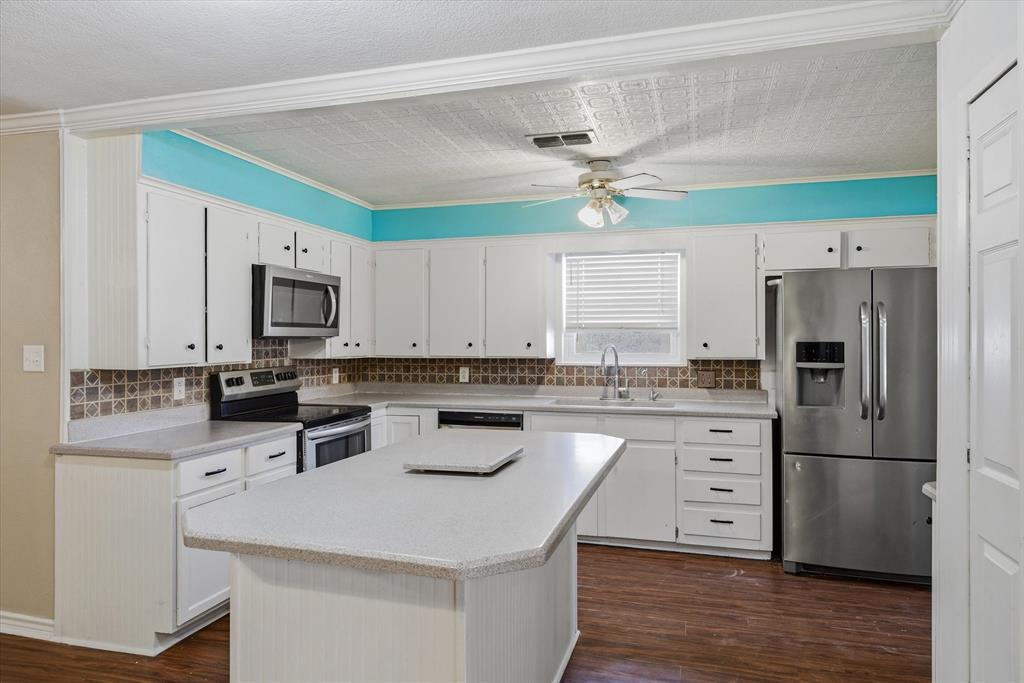 1729 Elliot Drive Canton, TX 75103 - Photo 7 of 40 Kitchen featuring ornamental molding, stainless steel appliances, an ornate ceiling, dark wood-style flooring, and white cabinetry