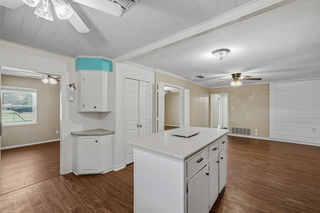 1729 Elliot Drive Canton, TX 75103 - Photo 8 of 40 Kitchen featuring ceiling fan, white cabinetry, a kitchen island, light countertops, and dark wood finished floors