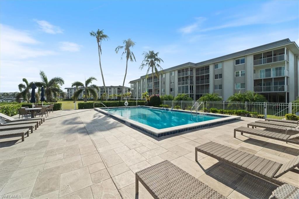 307 Goodlette-Frank Road, Unit B202 Naples, FL 34102 - Photo 18 of 21 a view of a swimming pool with a garden