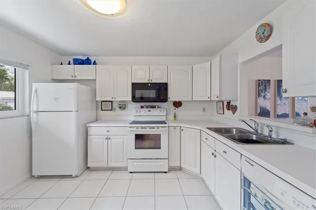 a kitchen with a refrigerator sink and cabinets