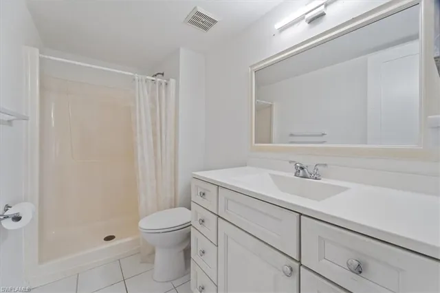a bathroom with a granite countertop sink a toilet and a mirror