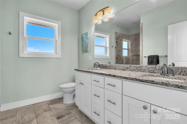 a bathroom with a granite countertop sink toilet and shower