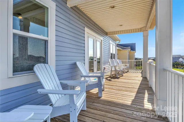 a view of a porch with wooden floor and outdoor seating