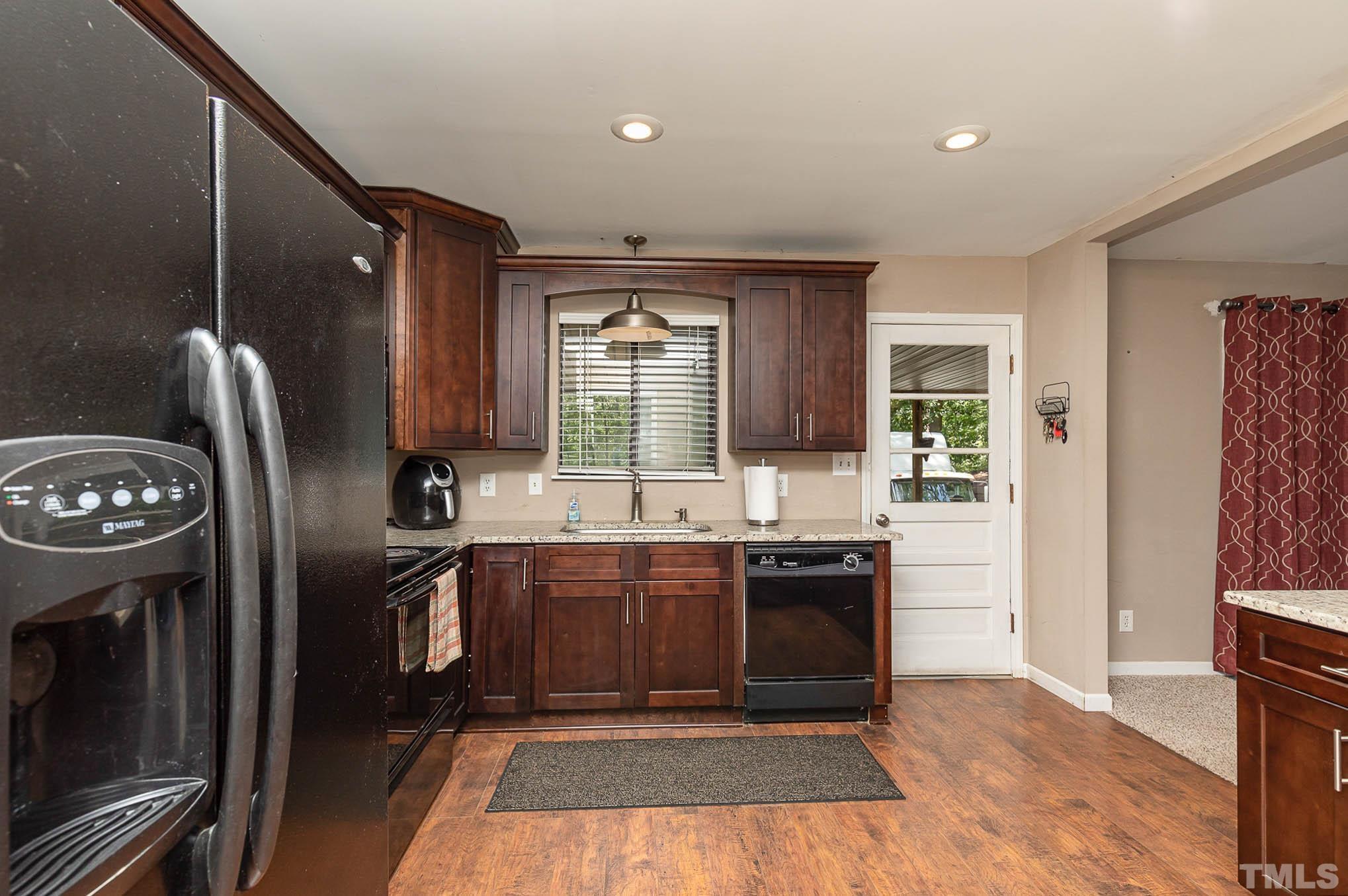 5609 Roslyn Road Durham, NC 27712 - Photo 12 of 31 a kitchen with stainless steel appliances granite countertop a refrigerator a sink a stove and island