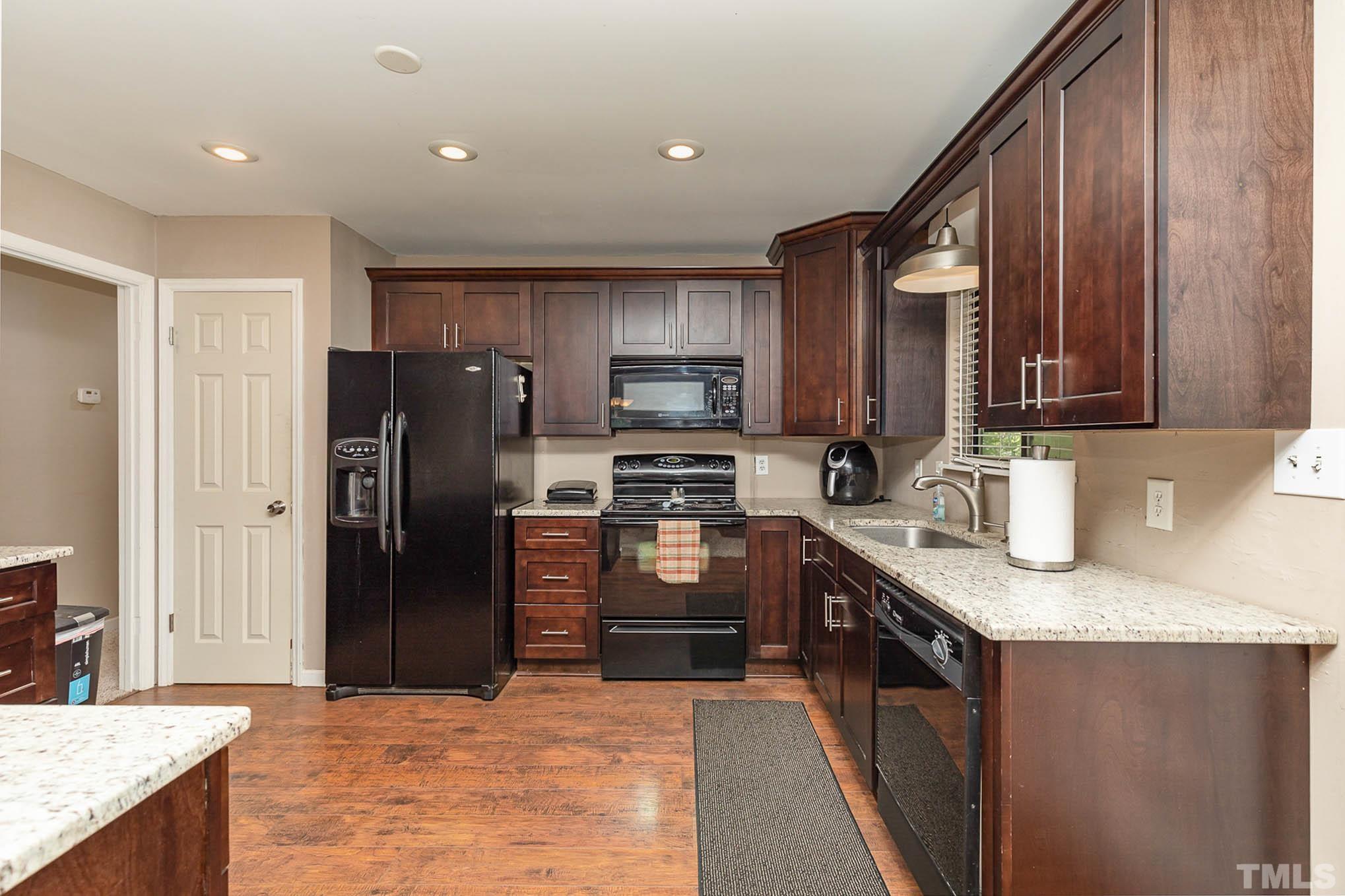 5609 Roslyn Road Durham, NC 27712 - Photo 13 of 31 a kitchen with granite countertop stainless steel appliances and wooden cabinets