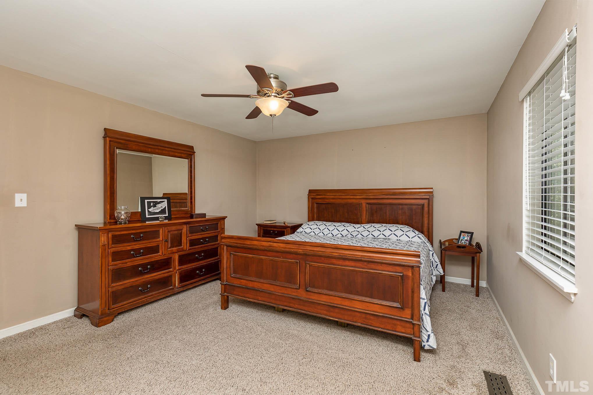 5609 Roslyn Road Durham, NC 27712 - Photo 15 of 31 a bedroom with a bed and a chandelier
