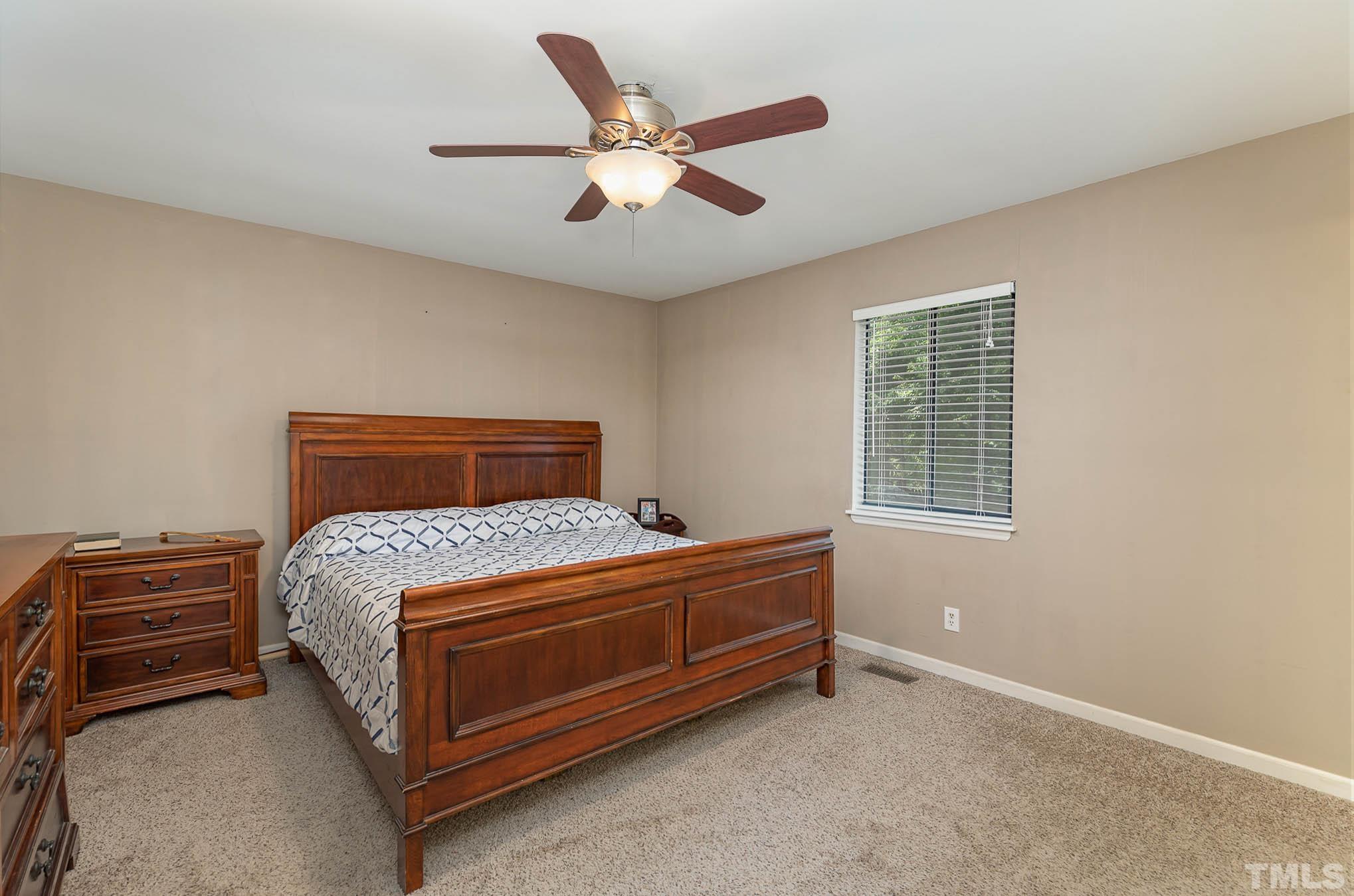 5609 Roslyn Road Durham, NC 27712 - Photo 16 of 31 a bedroom with a bed and a ceiling fan