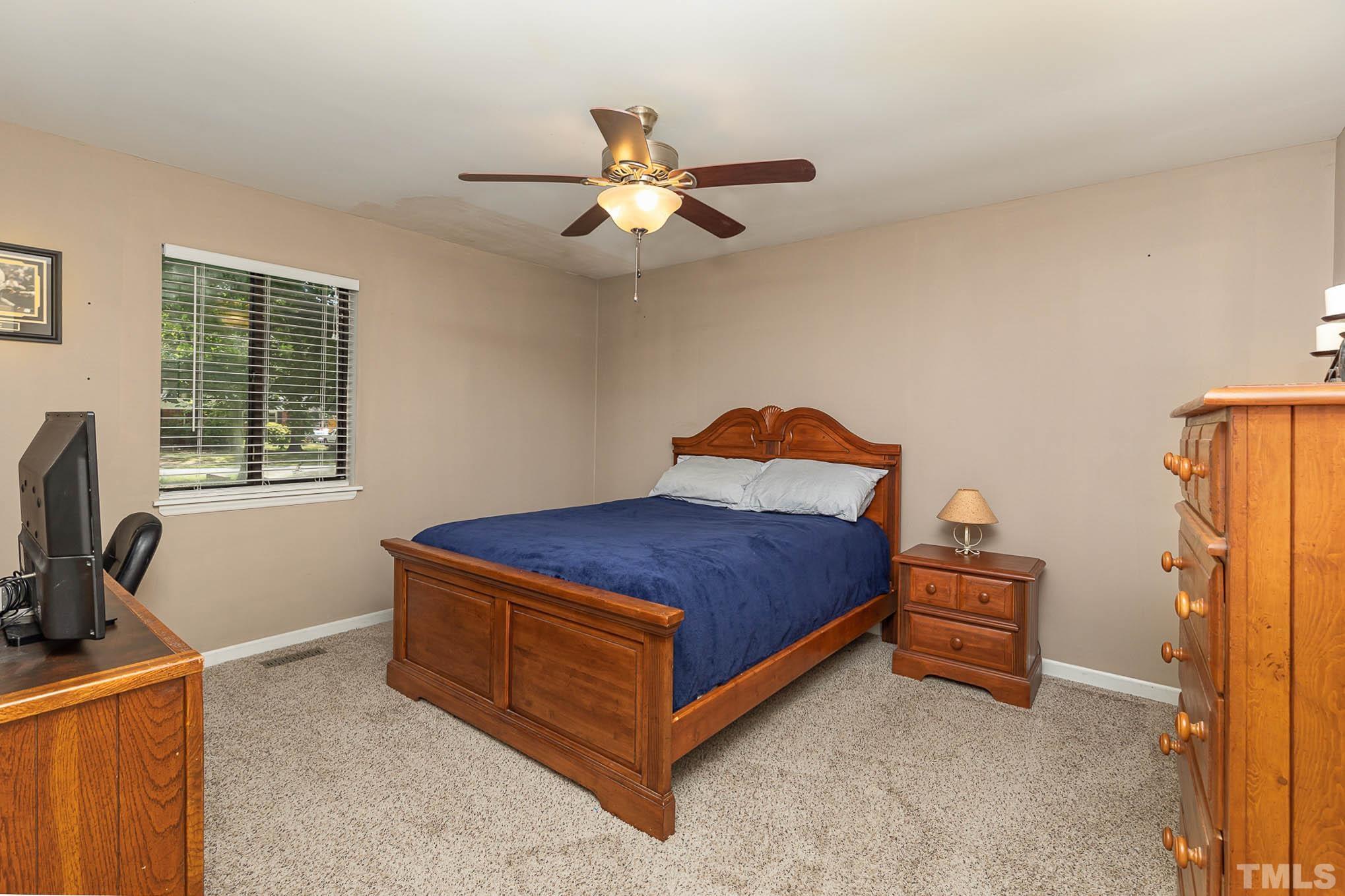 5609 Roslyn Road Durham, NC 27712 - Photo 18 of 31 a bedroom with a bed and a tv on a dresser