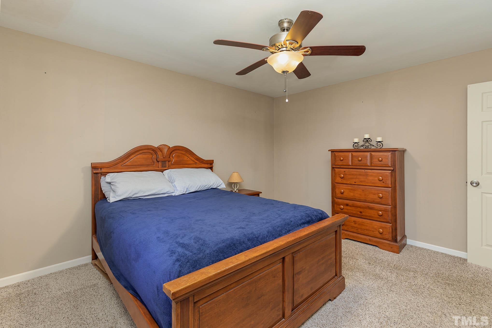 5609 Roslyn Road Durham, NC 27712 - Photo 19 of 31 a bed room with a bed and a ceiling fan