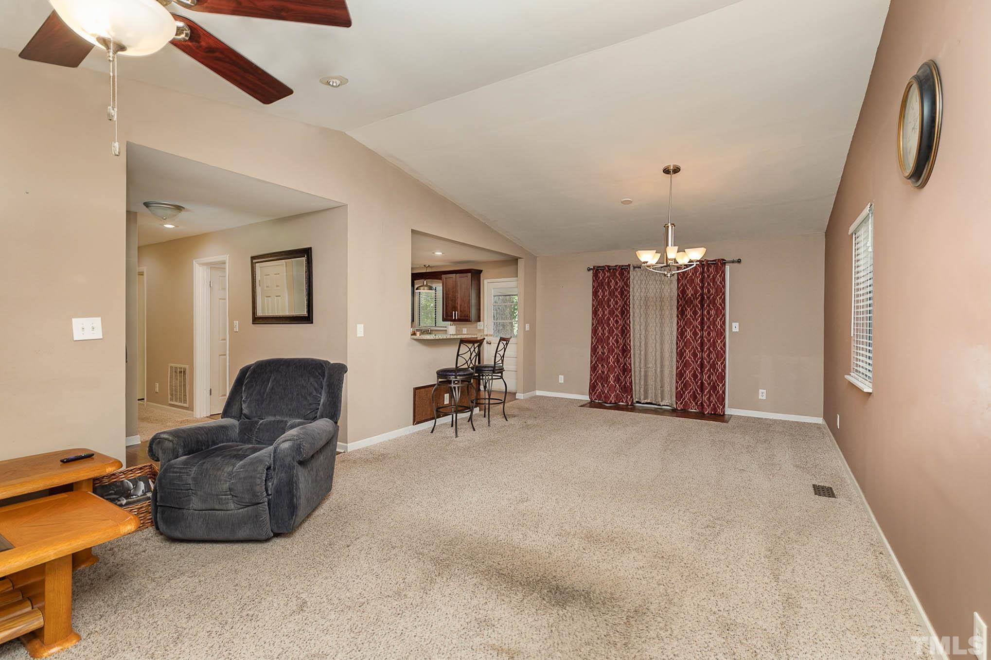 5609 Roslyn Road Durham, NC 27712 - Photo 8 of 31 a living room with furniture and a chandelier