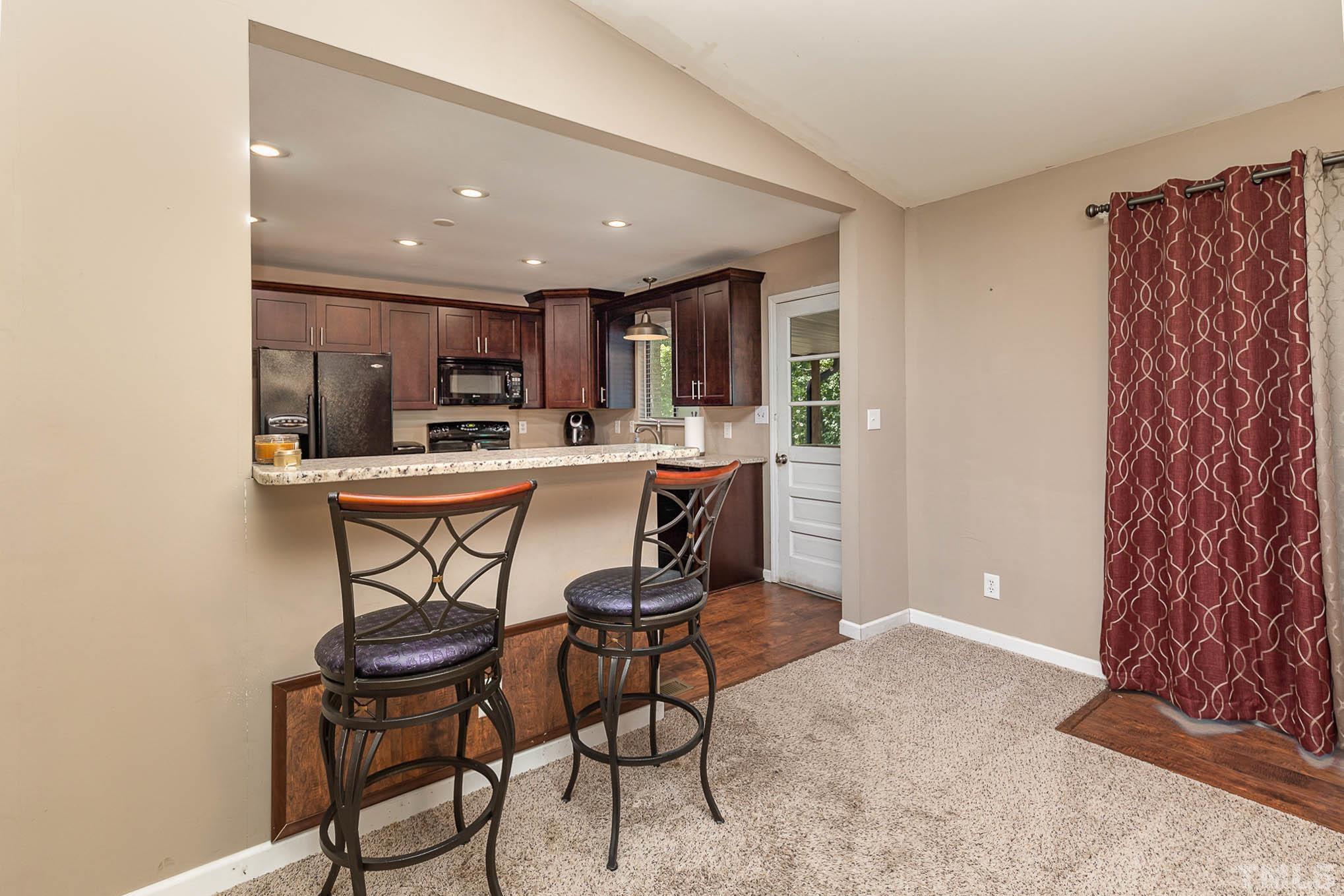 5609 Roslyn Road Durham, NC 27712 - Photo 10 of 31 a kitchen with a table chairs a sink and dishwasher