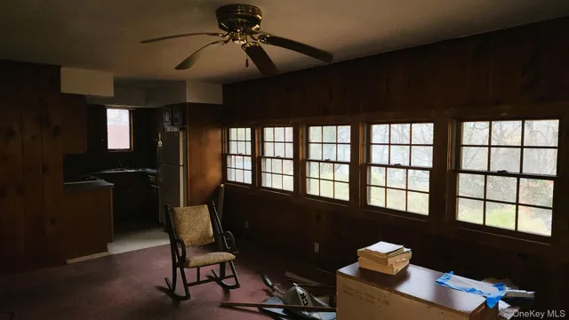 a view of a workspace with furniture and a window