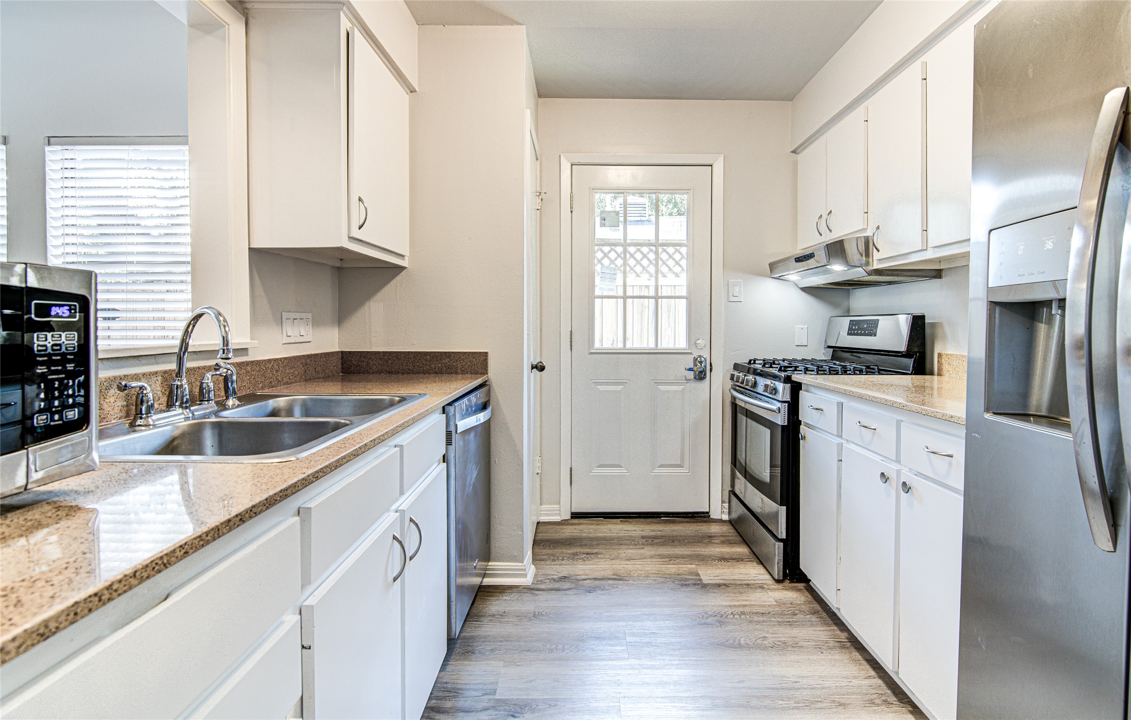 311 West Mary Street Austin, TX 78704 - Photo 27 of 35 A well-appointed kitchen features ample white cabinetry and durable stone counters, creating a functional cooking space.