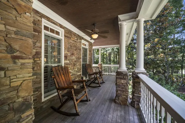 a balcony with chairs and wooden floor
