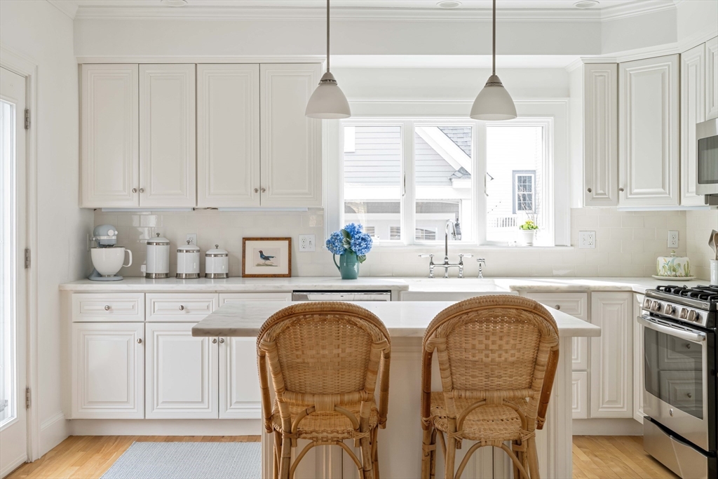 106 Florence Avenue Arlington, MA 02476 - Photo 3 of 34 a kitchen with stainless steel appliances granite countertop a stove a sink a refrigerator white cabinets and wooden floor