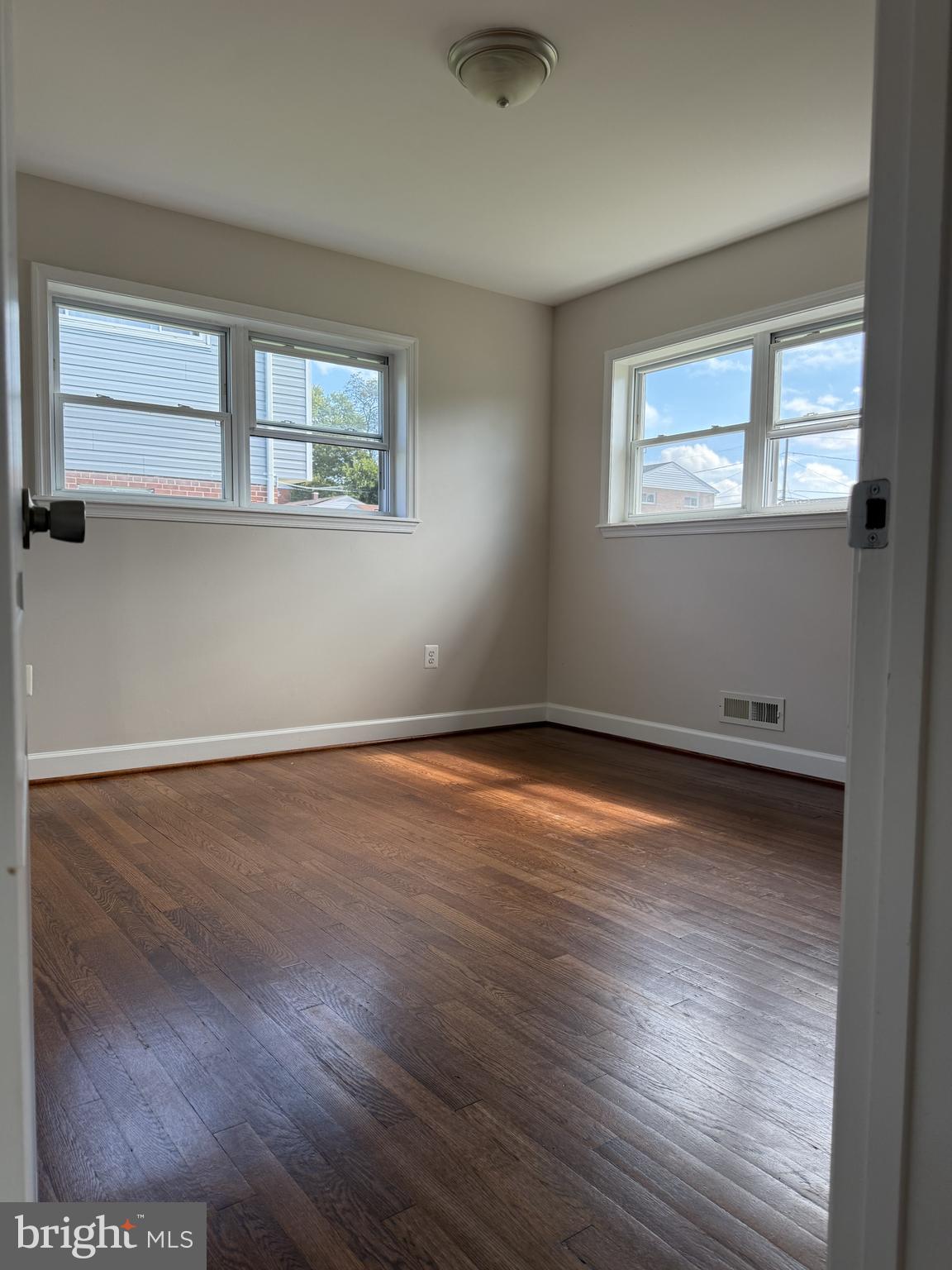 908 Vanderwood Road Catonsville, MD 21228 - Photo 21 of 36 a view of an empty room with wooden floor and a window
