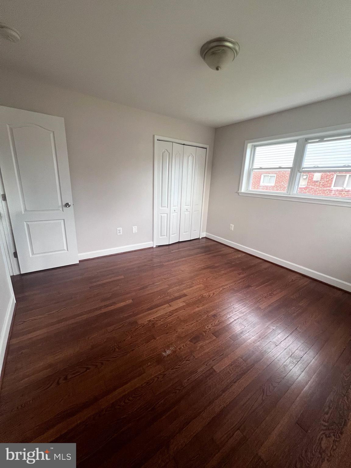 908 Vanderwood Road Catonsville, MD 21228 - Photo 22 of 36 a view of an empty room with wooden floor and a window