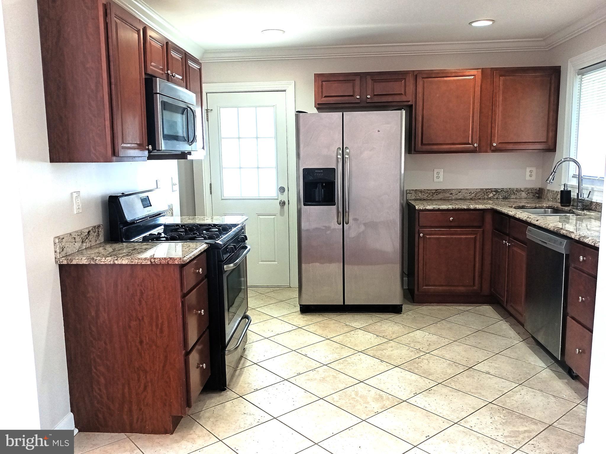 908 Vanderwood Road Catonsville, MD 21228 - Photo 9 of 36 a kitchen with stainless steel appliances granite countertop a refrigerator a stove a sink and dishwasher