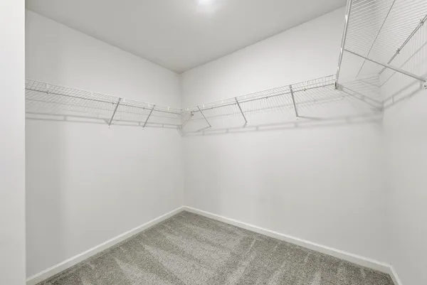 an empty room with windows and chandelier fan