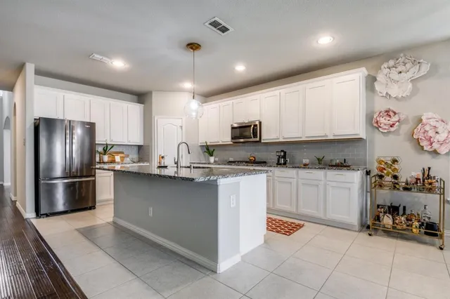a kitchen with stainless steel appliances granite countertop a refrigerator and a stove top oven