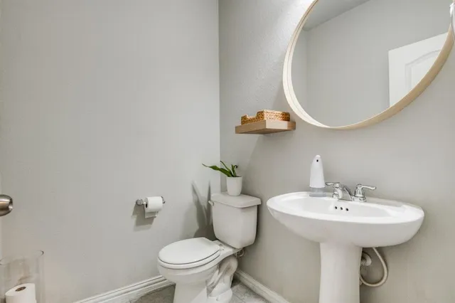 a bathroom with a sink toilet and a mirror