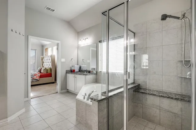 a bathroom with a tub a mirror and shower