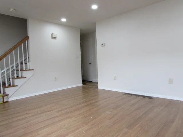 a view of an empty room with wooden floor