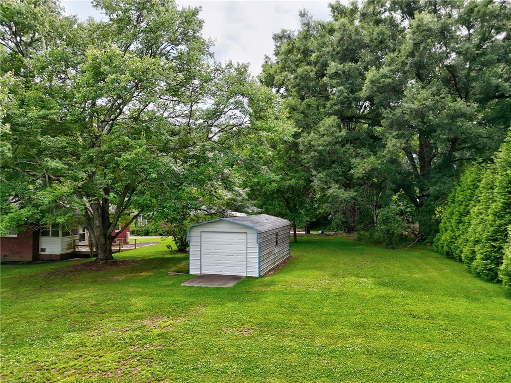 102 Graham Honea Path, SC 29654 - Photo 26 of 29 A verdant backyard with mature trees and a detached storage shed offers ample outdoor space.