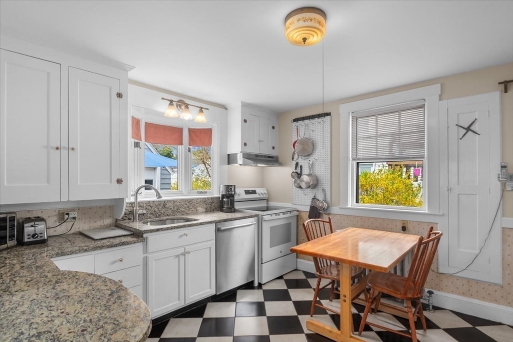 62 Washington Avenue Needham, MA 02492 - Photo 17 of 42 a kitchen with stainless steel appliances granite countertop a sink a stove a refrigerator a dining table and chairs with wooden floor