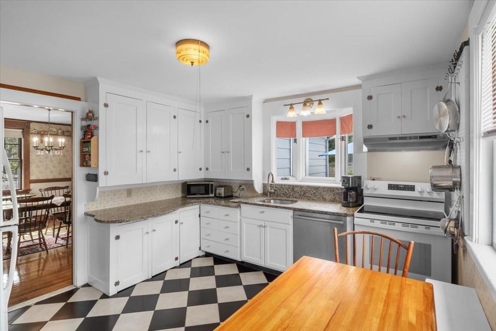 62 Washington Avenue Needham, MA 02492 - Photo 18 of 42 a kitchen with stainless steel appliances granite countertop a sink a stove a chimney a refrigerator and cabinets