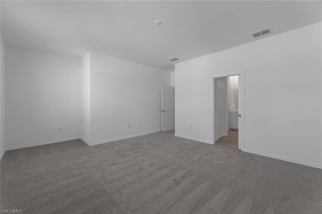 2856 Citrus Street Naples, FL 34120 - Photo 11 of 20 Unfurnished bedroom featuring light carpet and ensuite bath