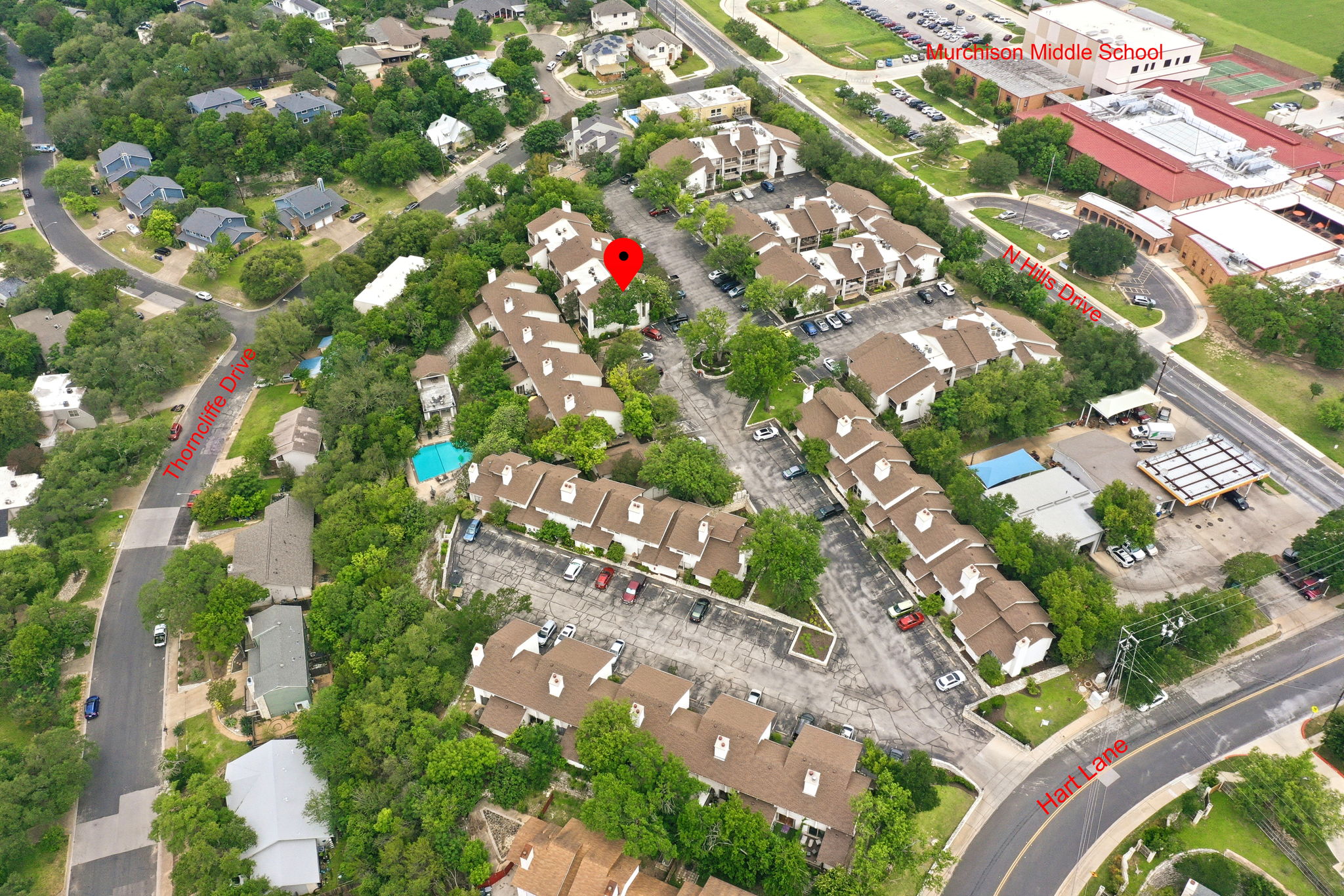 6910 Hart Lane, Unit 912 Austin, TX 78731 - Photo 28 of 36 Aerial view showcasing a residential community with multiple buildings, mature tree cover, and paved roadways