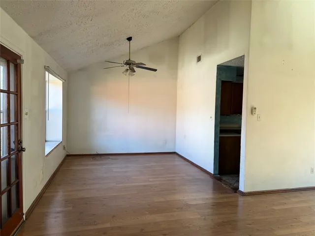 a view of a hallway with wooden floor and a living room