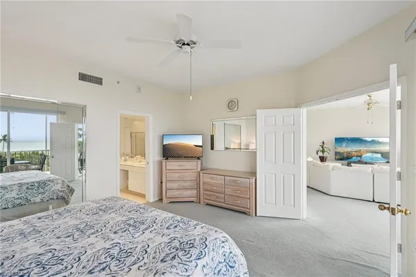 a spacious bedroom with a bed and a view of living room