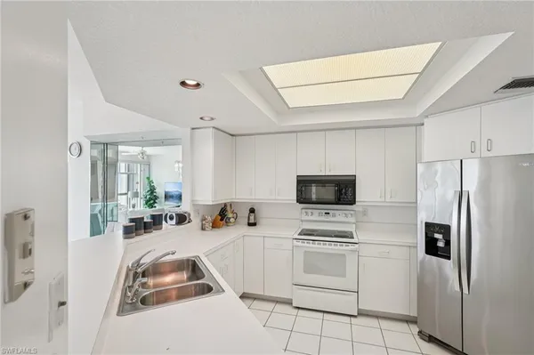 a kitchen with white cabinets and white appliances