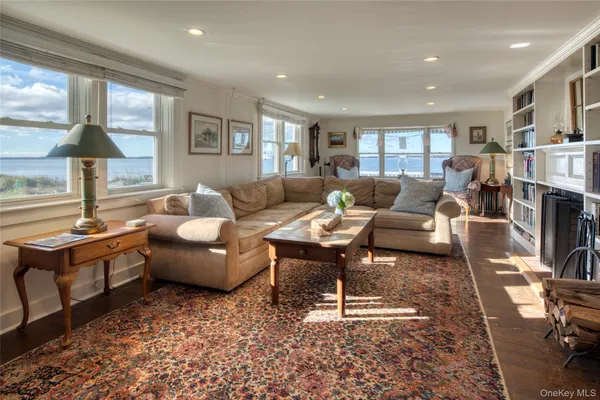 a living room with fireplace furniture and a rug