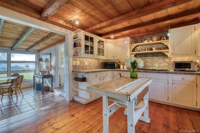 a kitchen with granite countertop a table chairs stove and cabinets