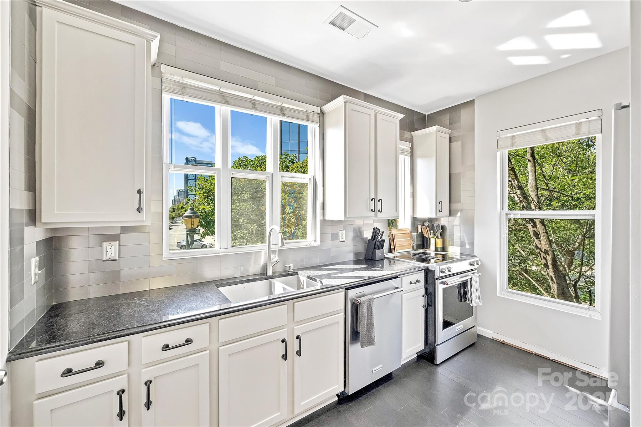 1425 Camden Road Charlotte, NC 28203 - Photo 12 of 37 a kitchen with stainless steel appliances white cabinets and a large window