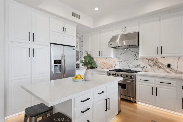 a kitchen with stainless steel appliances a sink stove and refrigerator