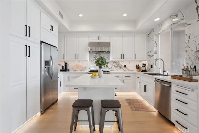 a kitchen with white cabinets and stainless steel appliances