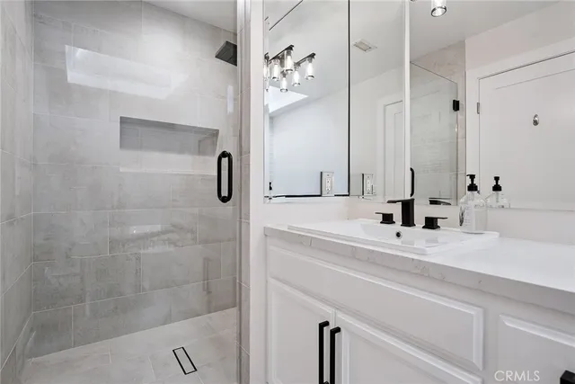 a bathroom with a double vanity sink mirror and shower