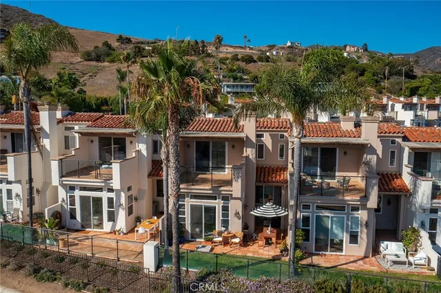 a front view of a building with a garden and plants