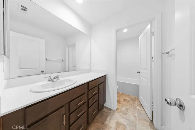 a bathroom with a sink double vanity granite tub and shower