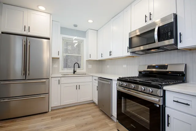 a kitchen with stainless steel appliances a stove microwave and sink