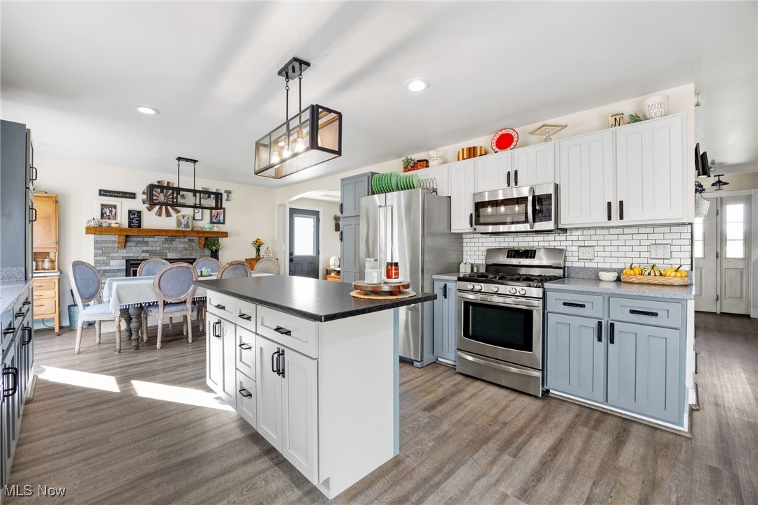 11827 Stratton Road West Salem, OH 44287 - Photo 22 of 47 Kitchen with white cabinetry, arched walkways, stainless steel appliances, backsplash, and dark countertops
