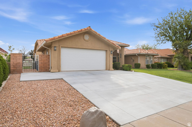 1985 West Rivers Edge Lane St. George, UT 84770 - Photo 10 of 42 View of front of home featuring a garage, concrete driveway, a tiled roof, a gate, and stucco siding