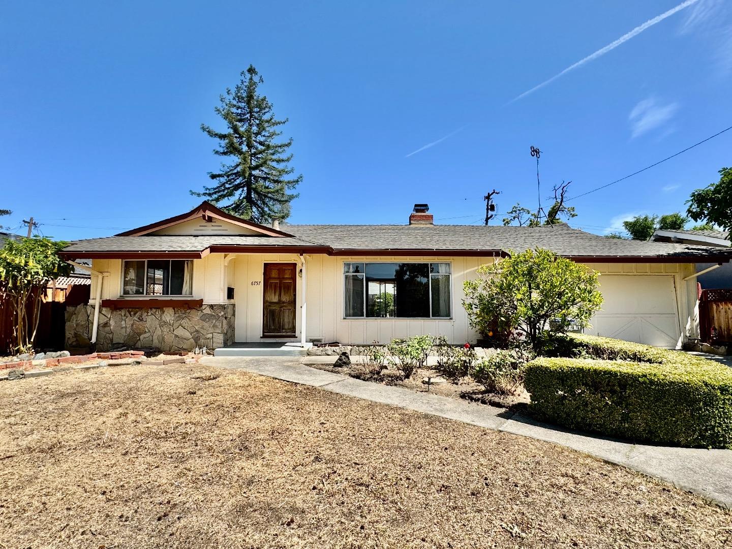 a front view of a house with a yard outdoor seating and garage
