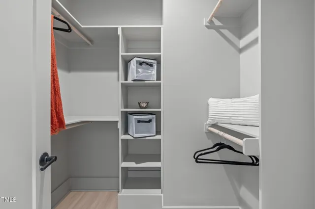 a room with a walk in closet and a mirror